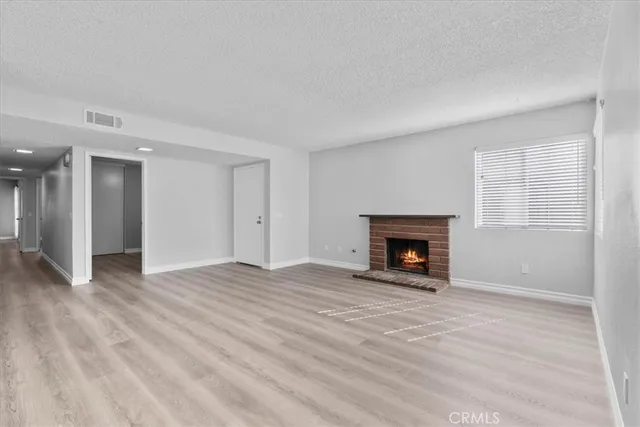 a view of an empty room with a window and fireplace