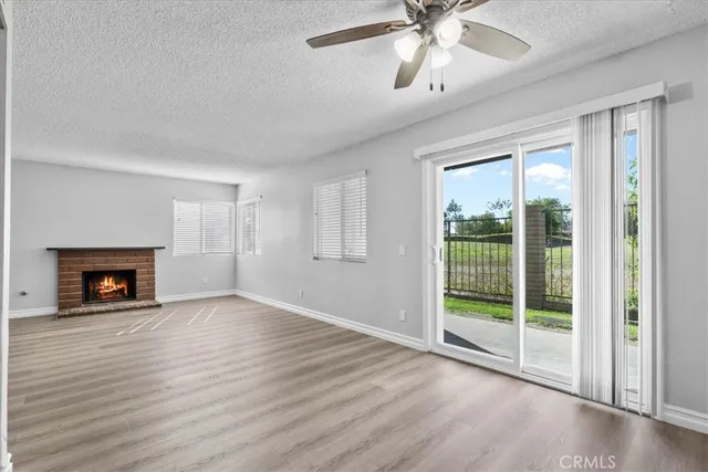 a view of an empty room with a fireplace and a window