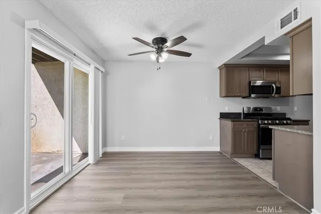 a kitchen with stainless steel appliances white cabinets and a stove top oven