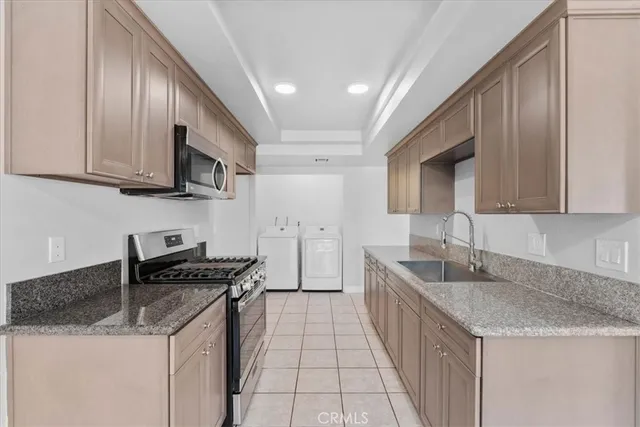 a kitchen with stainless steel appliances granite countertop a sink stove and cabinets