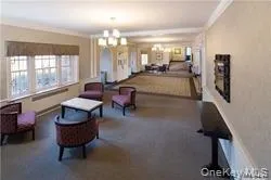 a living room with furniture a flat screen tv and a large window