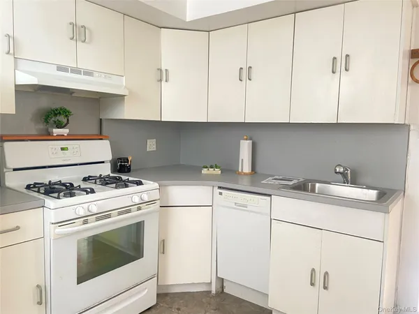 a kitchen with cabinets appliances a sink and a stove