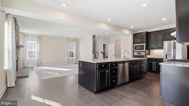 a large kitchen with stainless steel appliances and wooden cabinets