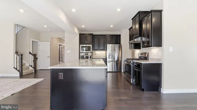 a kitchen with stainless steel appliances granite countertop a refrigerator and a stove