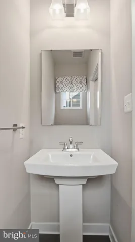 a white sink sitting under a bathroom mirror