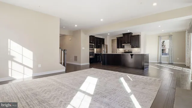 a kitchen with stainless steel appliances kitchen island granite countertop a refrigerator and a sink