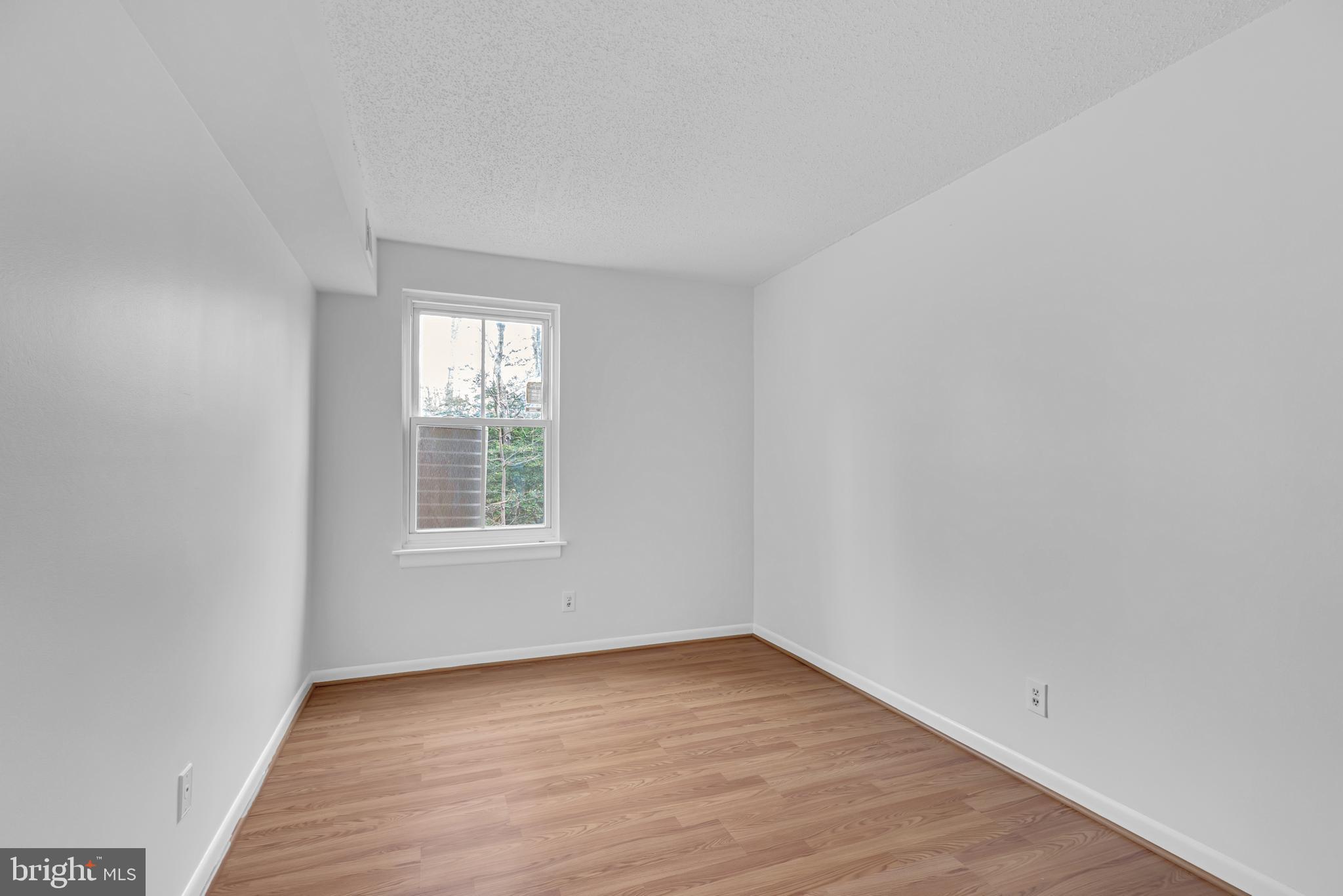 11637 Stoneview Square, Unit 2B Reston, VA 20191 - Photo 23 of 31 an empty room with wooden floor and window