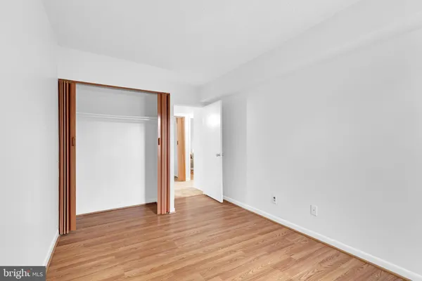 an empty room with wooden floor and window