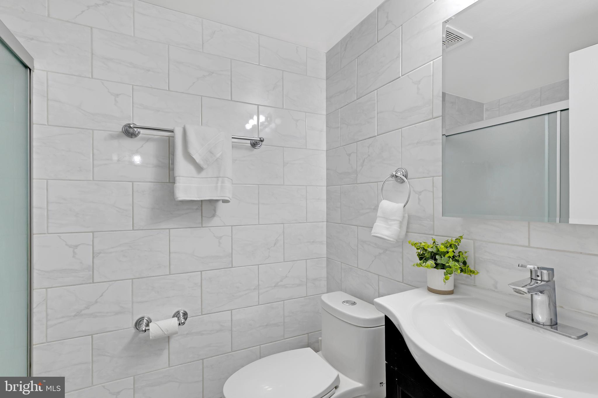 11637 Stoneview Square, Unit 2B Reston, VA 20191 - Photo 25 of 31 a bathroom with a sink toilet and shower