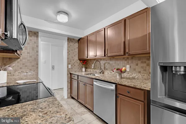 a kitchen with stainless steel appliances granite countertop a sink stove and cabinets