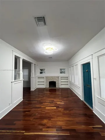 a view of a hallway with wooden floor and a fireplace