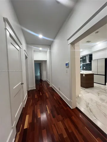 a view of a room with wooden floor and kitchen