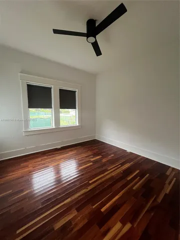 a view of empty room with window and wooden floor