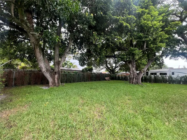 a view of a backyard with large trees