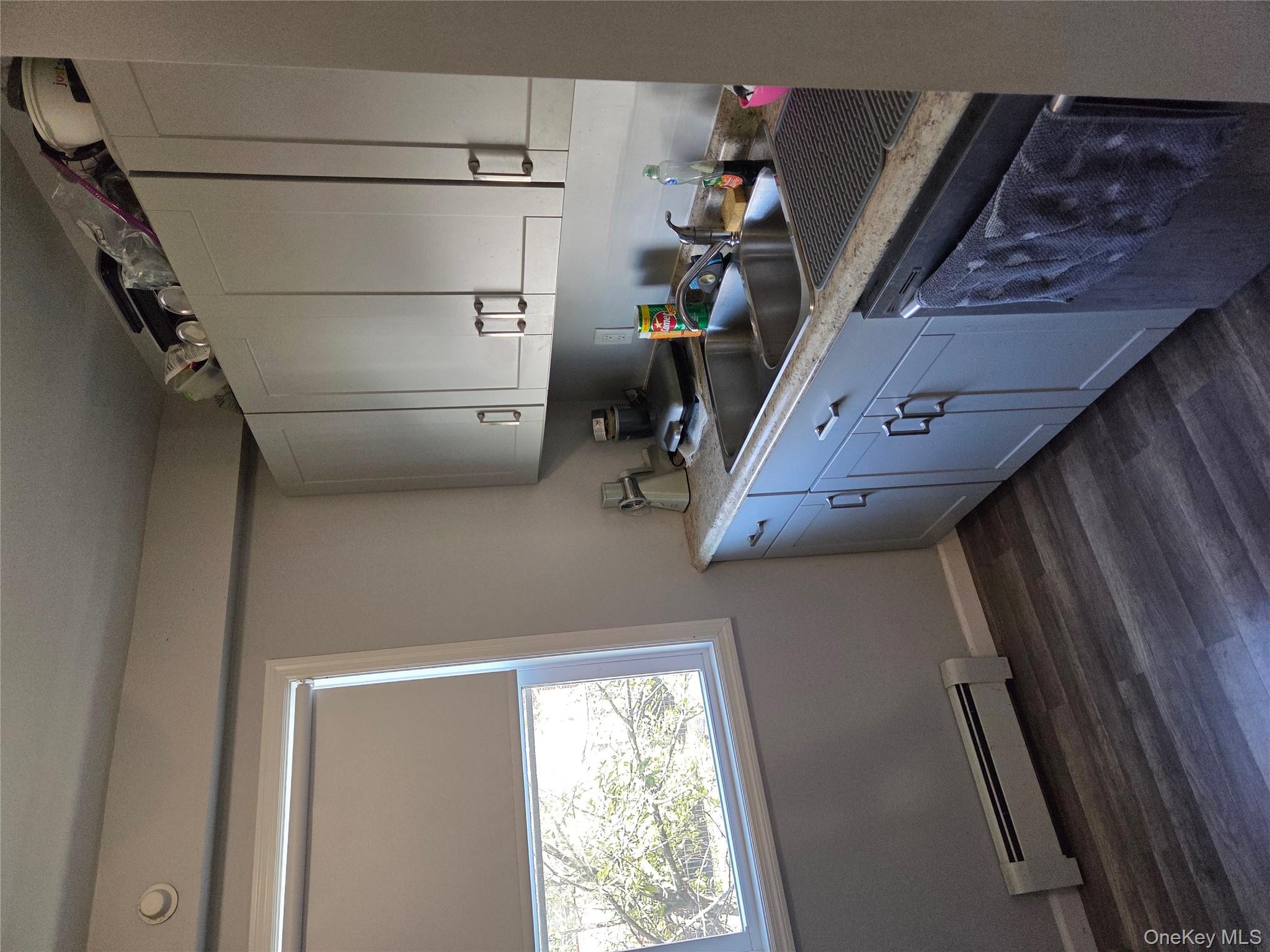 3095 Mullan Place Bronx, NY 10465 - Photo 7 of 12 Kitchen featuring a baseboard radiator, light countertops, dark wood finished floors, and dishwasher