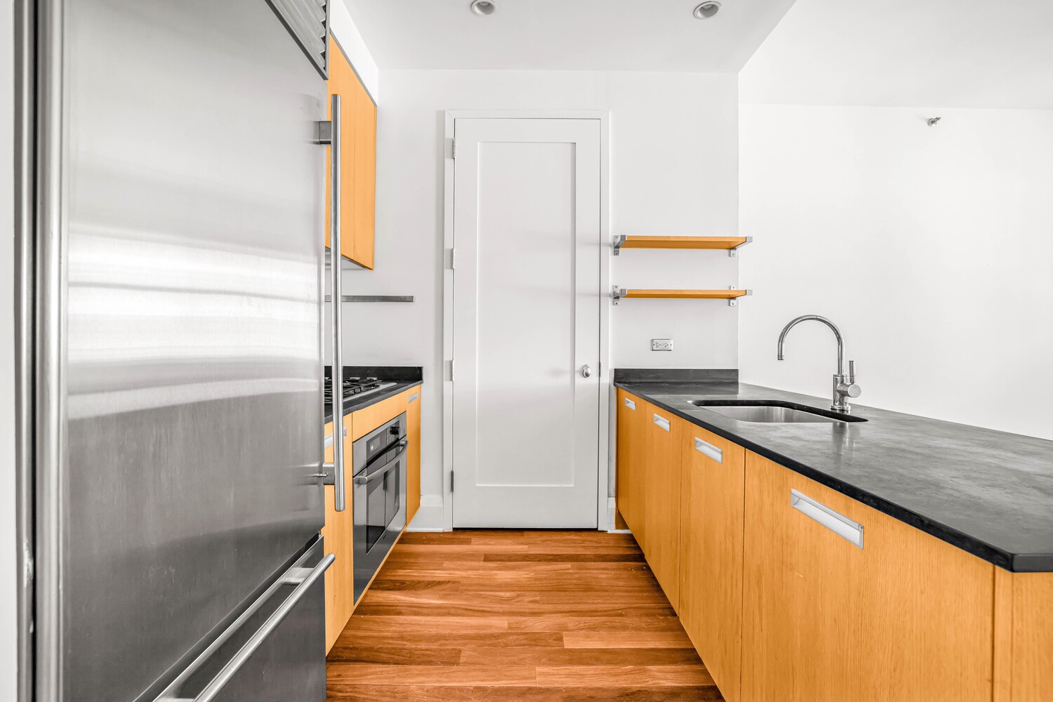 71 Nassau Street, Unit 3B Manhattan, NY 10038 - Photo 4 of 9 a hallway with view of the kitchen sink and wooden floor