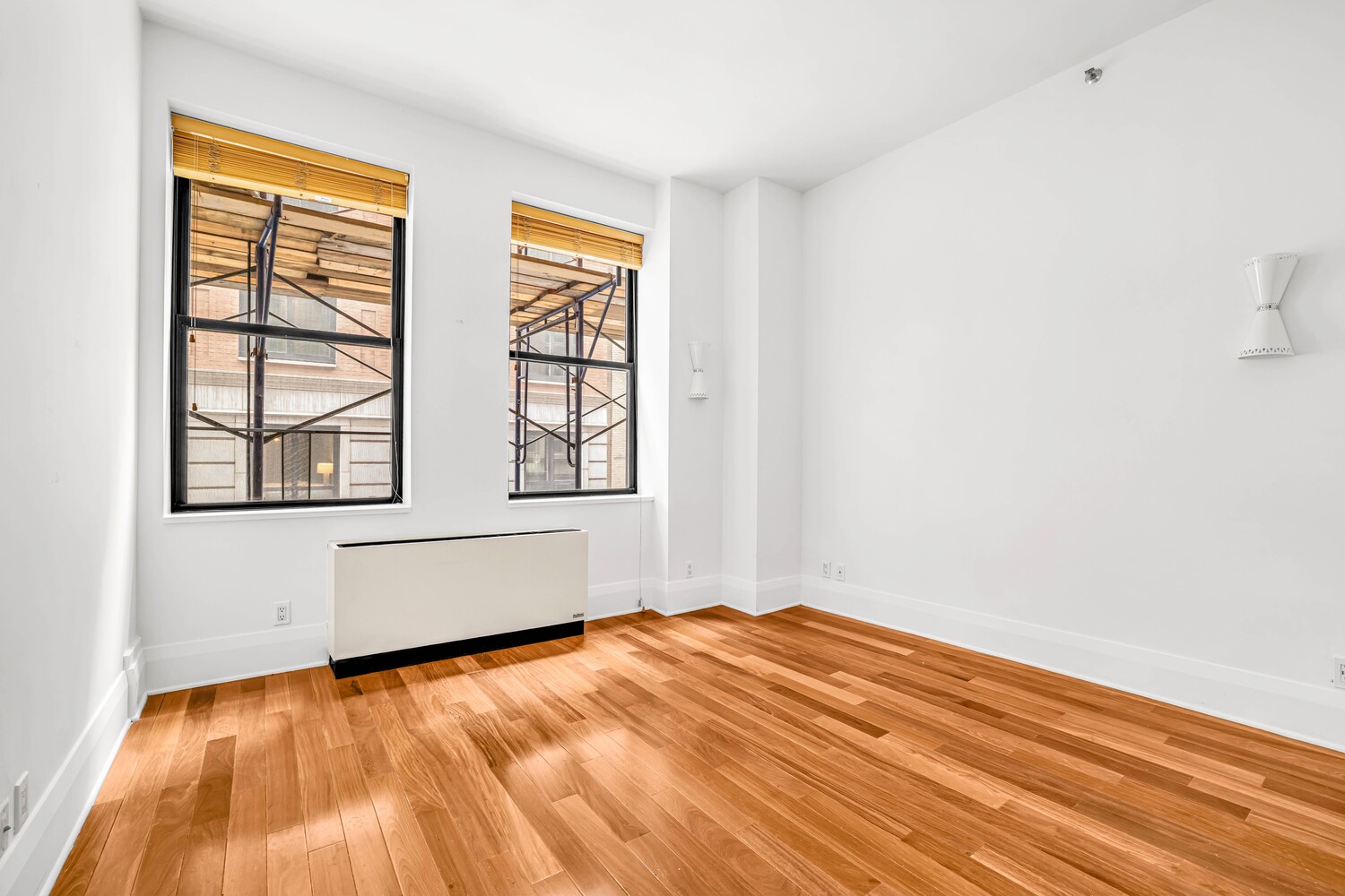 71 Nassau Street, Unit 3B Manhattan, NY 10038 - Photo 6 of 9 an empty room with wooden floor and windows