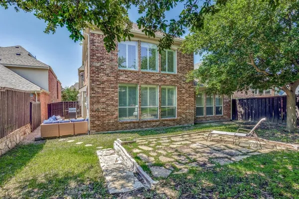a view of a house with backyard and a tree