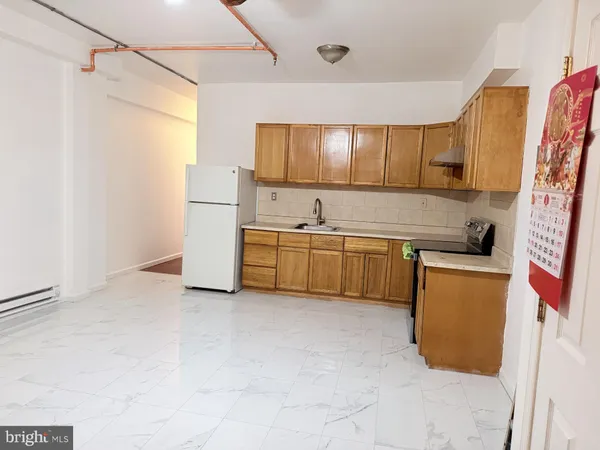a kitchen with a sink a refrigerator and cabinets