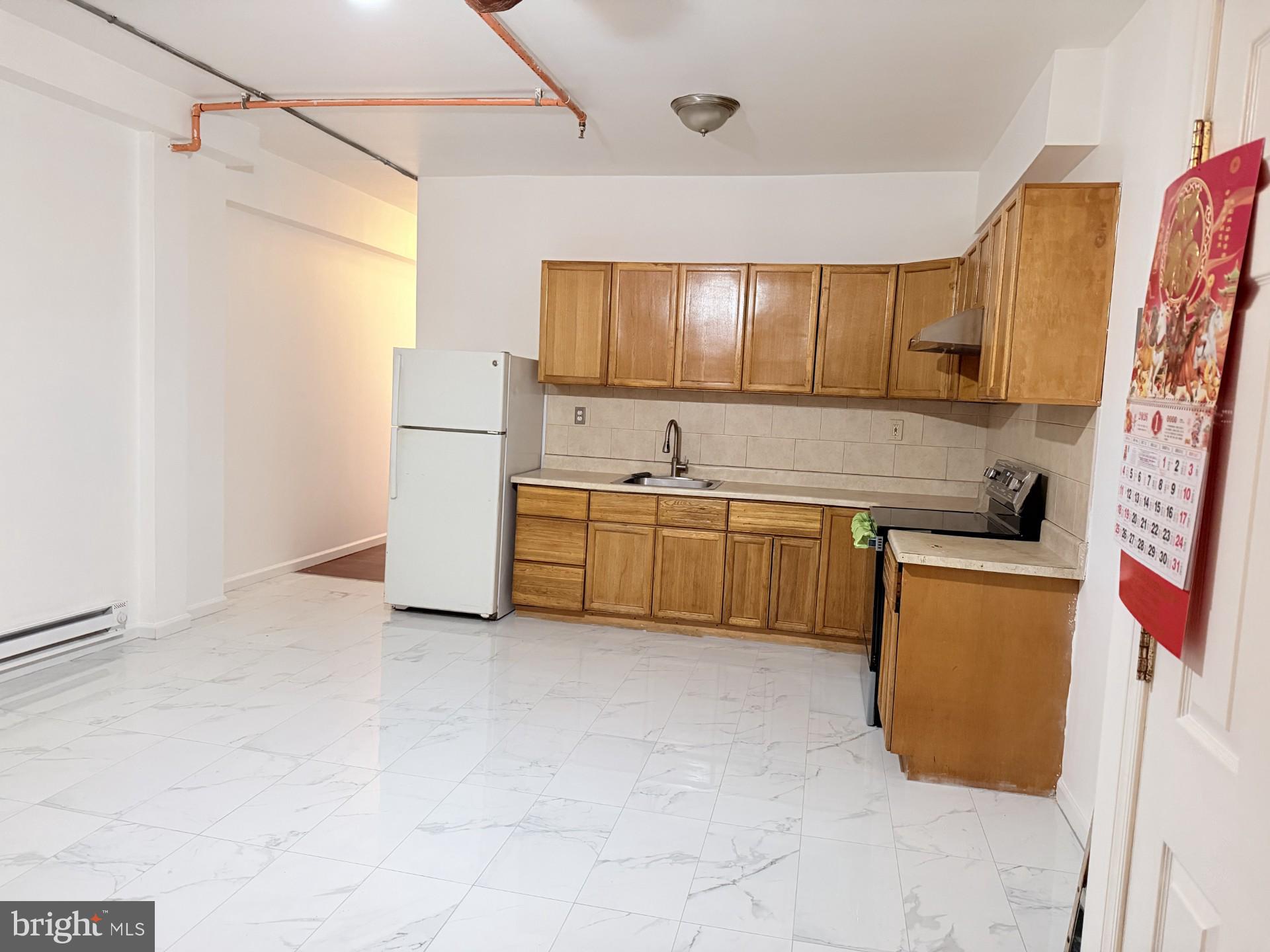 1438 Federal Street Philadelphia, PA 19146 - Photo 7 of 10 a kitchen with a sink a refrigerator and cabinets