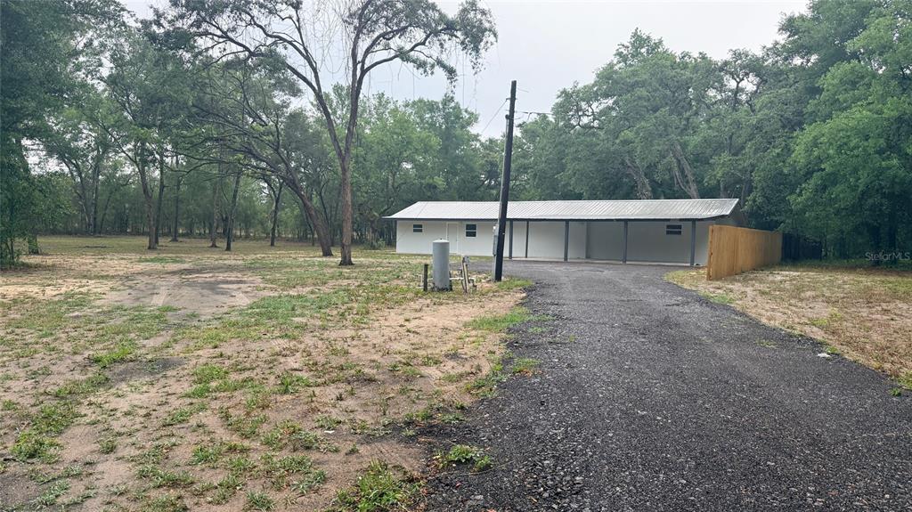 15535 Little Ranch Road Spring Hill, FL 34610 - Photo 2 of 46 a backyard of a house with large trees and wooden fence