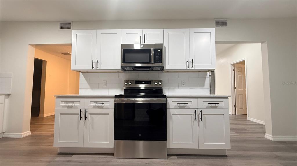 15535 Little Ranch Road Spring Hill, FL 34610 - Photo 5 of 46 a kitchen with cabinets stainless steel appliances and wooden floor