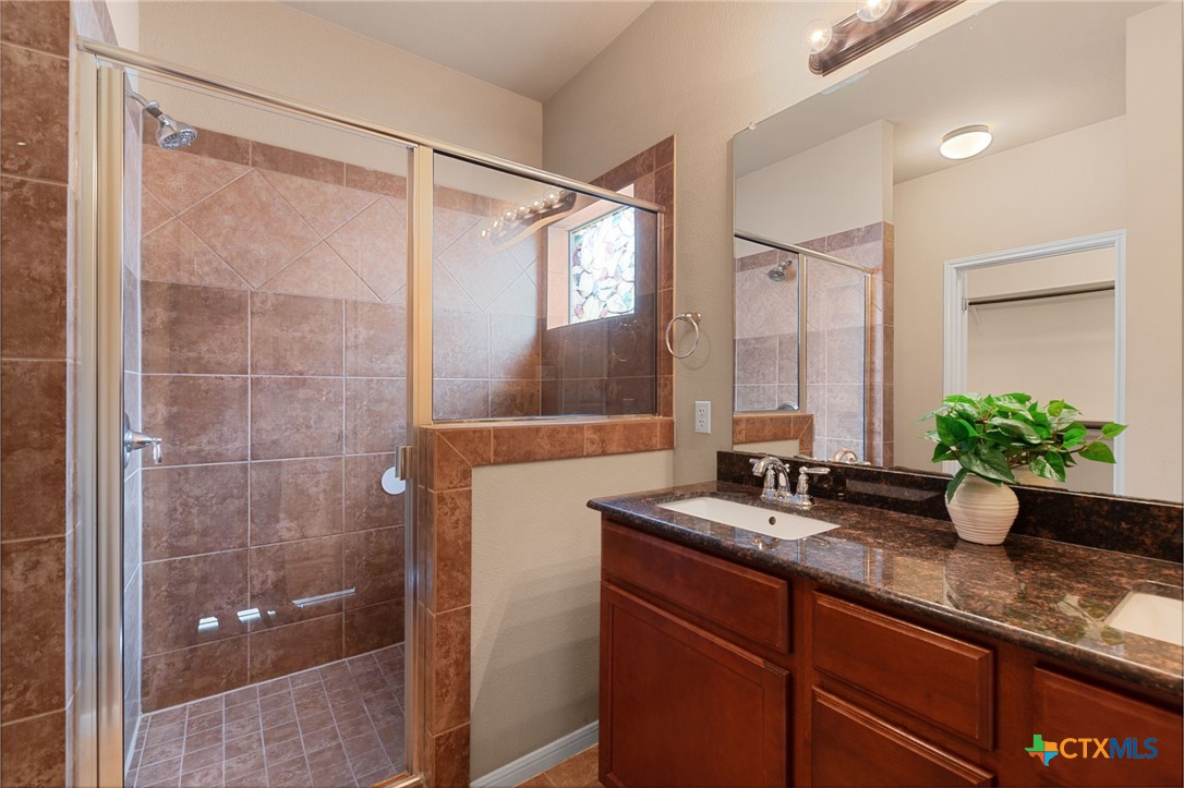 408 Copper Ridge Loop Temple, TX 76502 - Photo 3 of 39 Primary bathroom showcasing a dual vanity, large glass vanity, and a glass enclosed walk-in shower