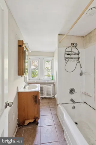 a bathroom with a tub sink and mirror
