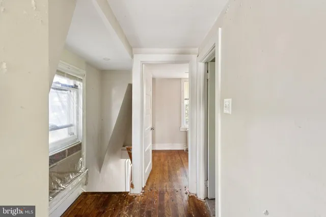a view of hallway with wooden floor and stairs