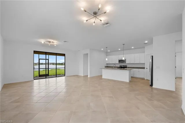 a view of an empty room with a kitchen