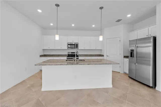a view of a kitchen with a sink and refrigerator