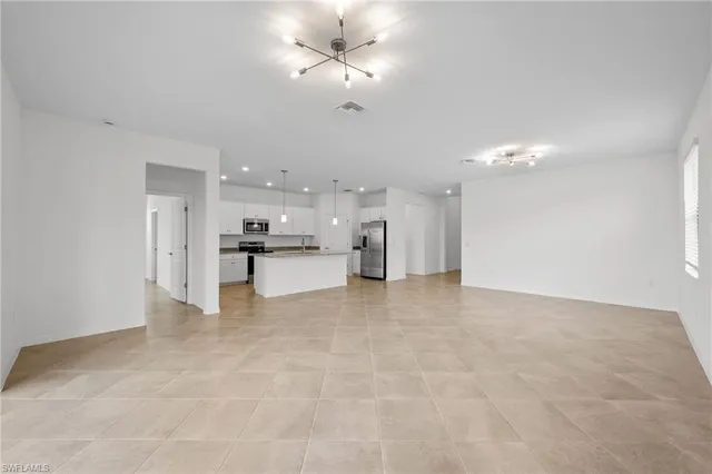 a view of a kitchen with kitchen island a sink stainless steel appliances and cabinets