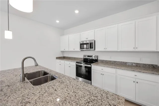 a kitchen with sink a stove and cabinets