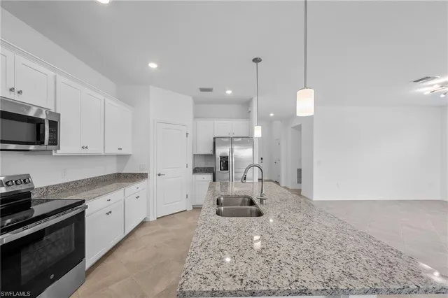 a large kitchen with white cabinets and stainless steel appliances