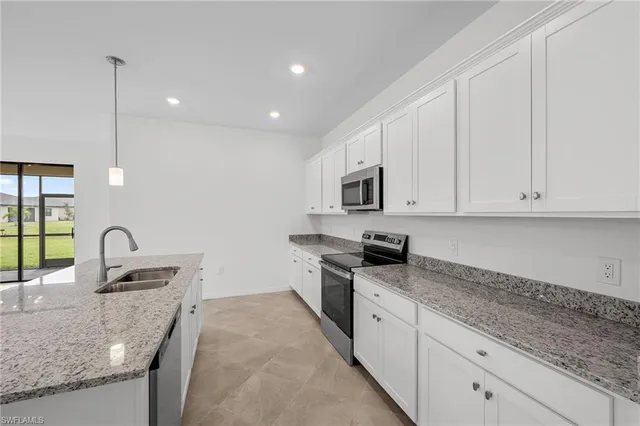 a kitchen with stainless steel appliances granite countertop a sink a stove and a granite counter tops