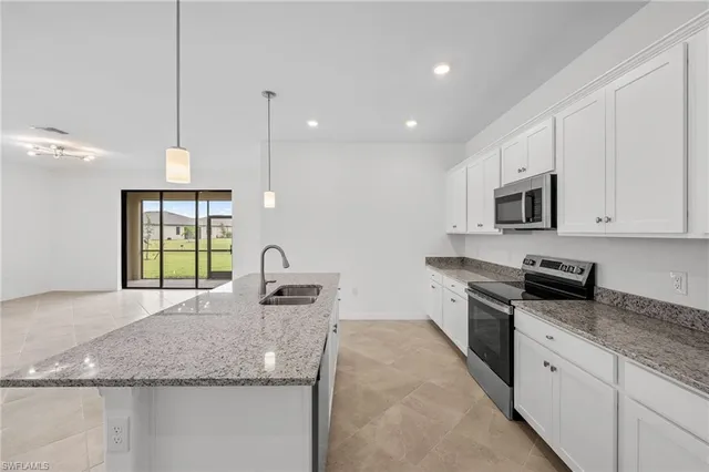 a kitchen with granite countertop stainless steel appliances sink stove microwave and cabinets