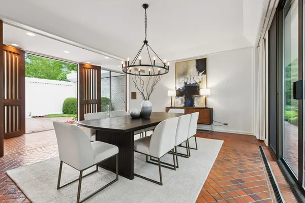 a dining room with furniture a chandelier and wooden floor