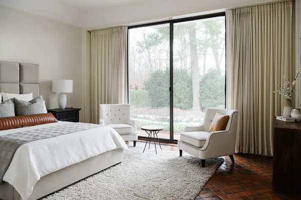 a bedroom with a bed and a large window