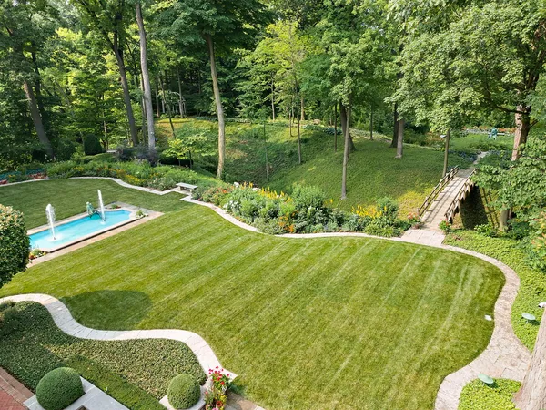 a view of a swimming pool with a garden and trees