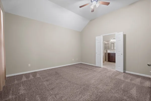 a view of an empty room with a chandelier fan