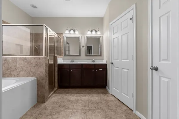 a bathroom with a granite countertop sink a mirror and a bathtub