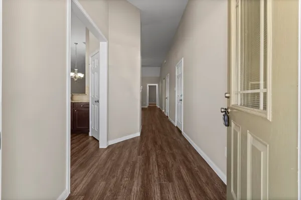 a view of a hallway with wooden floor and staircase