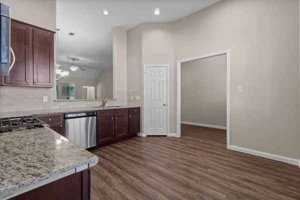 a kitchen with kitchen island granite countertop wooden cabinets and a sink