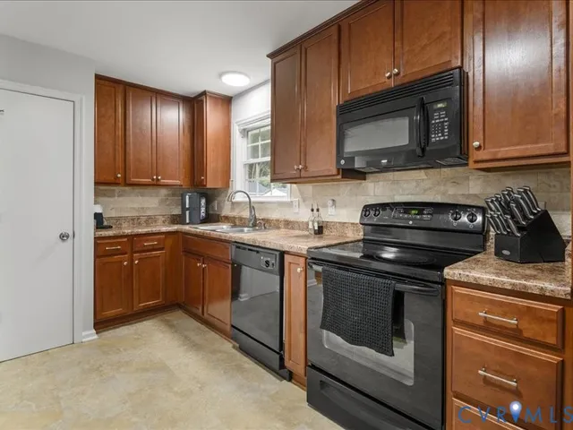 a kitchen with granite countertop wooden cabinets and a stove top oven