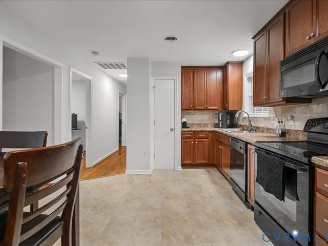 a kitchen with stainless steel appliances kitchen island granite countertop a stove a sink and a refrigerator