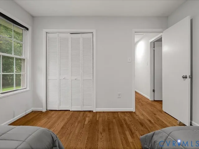 an empty room with wooden floor and closet