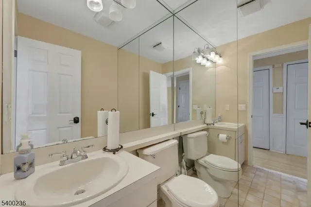 a spacious bedroom with a bed a couch and a chandelier