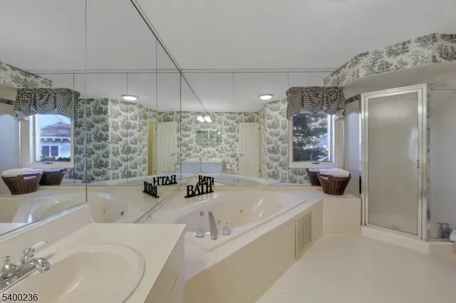 a bathroom with a double vanity sink mirror and bathtub