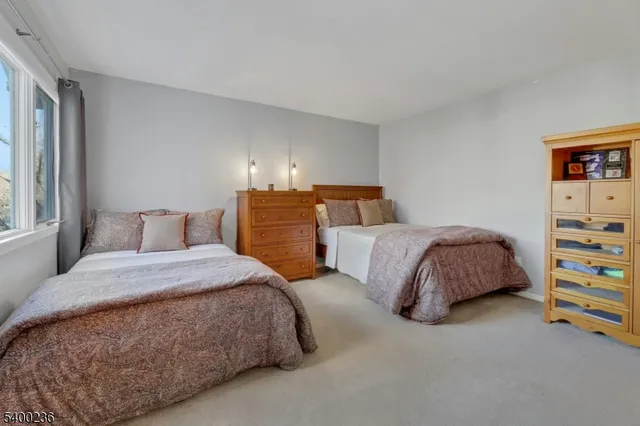 a bedroom with two beds and large windows