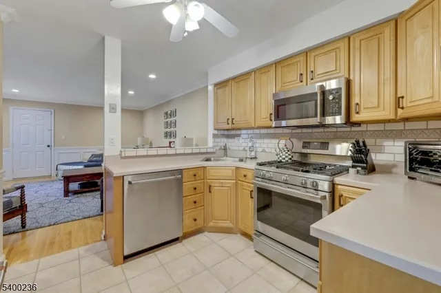 a kitchen with stainless steel appliances granite countertop a sink a stove and cabinets